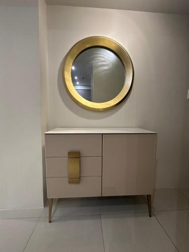 a mirror on a wall above a dresser in a room at Luxury Penthouse & High-Floor Hotel near City of Dreams, Airport, Okada, and Solaire Casino in Manila