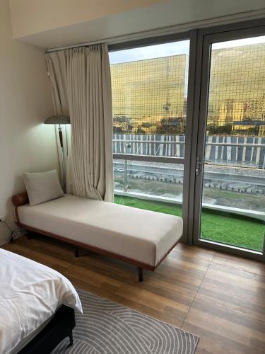 a bedroom with a bed and a large window at Luxury Penthouse & High-Floor Hotel near City of Dreams, Airport, Okada, and Solaire Casino in Manila