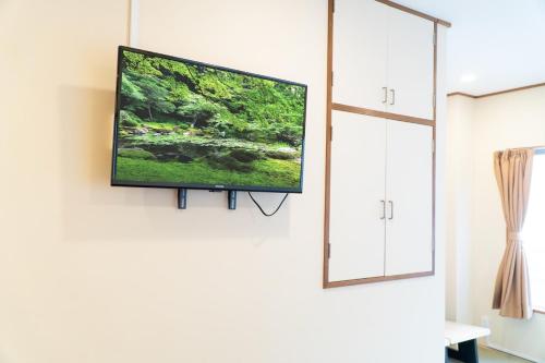 a flat screen tv hanging on a wall at Tokyo Tower Cozy Stay 201 Tamachi & Mita Access in Wada