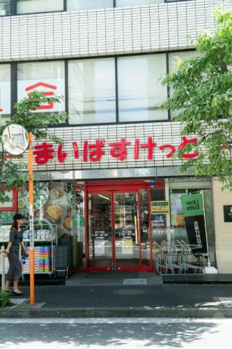 a store with a sign on the side of a building at Tokyo Tower Cozy Stay 201 Tamachi & Mita Access in Wada