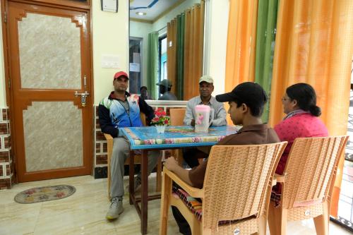 a group of people sitting around a table at maa kalishila home stay in Ukhimath