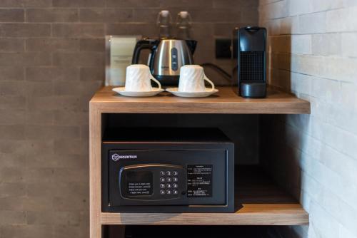 a microwave on a wooden shelf with a coffee maker at Na Tanao 1969 in Bangkok