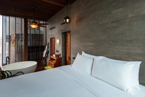 a bedroom with a large bed and a bath tub at Na Tanao 1969 in Bangkok