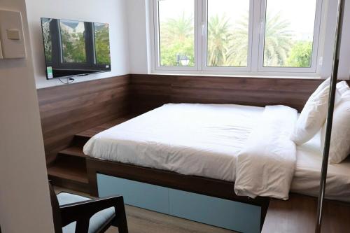 a bed in a room with two windows at Modern 3BR Villa , Poolside, 4min Shuttle to Beach in Bình Tú
