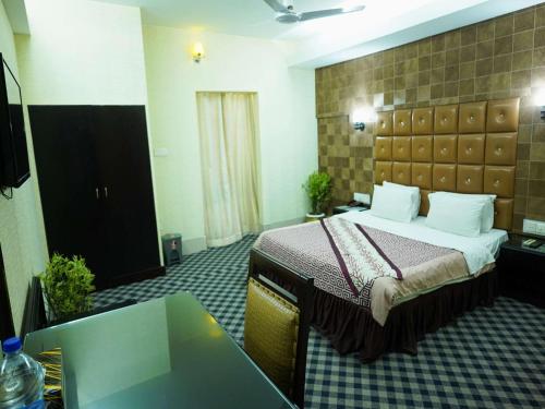 a hotel room with a bed and a table at Britannia Hotel in Sylhet