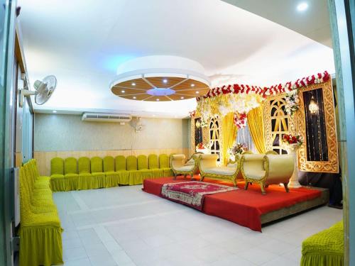 a waiting room with green chairs and a red carpet at Britannia Hotel in Sylhet