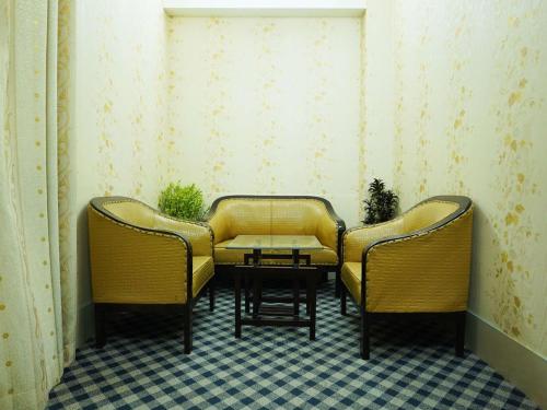 two chairs and a table in a room at Britannia Hotel in Sylhet
