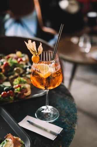 a drink on a table with a plate of food at O&O Hotel Oberursel Zentrum in Oberursel