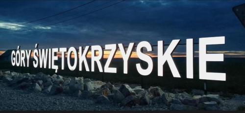a large sign that reads gaymiteivatingisel in front of rocks at Apartament u Moni in Krajno Pierwsze