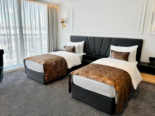 a hotel room with two beds and a window at Sky Airport Hotel in Cluj-Napoca