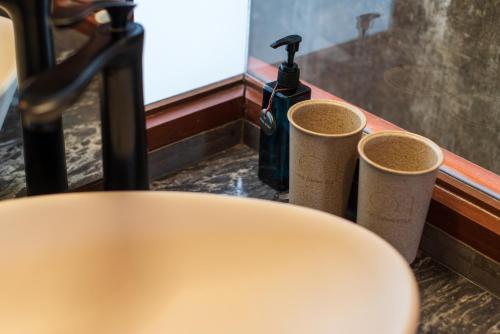 a counter with two cups and a bottle of soap at Na Tanao 1969 in Bangkok