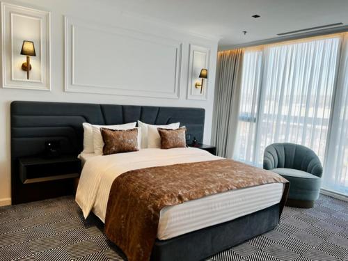 a bedroom with a large bed and a chair at Sky Airport Hotel in Cluj-Napoca