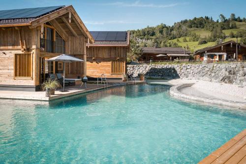 a swimming pool in front of a house at Alpzitt-Chalets in Burgberg