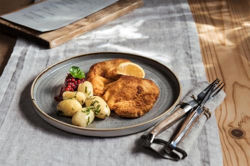 a plate of food with chicken and fruit on a table at Alpzitt-Chalets in Burgberg