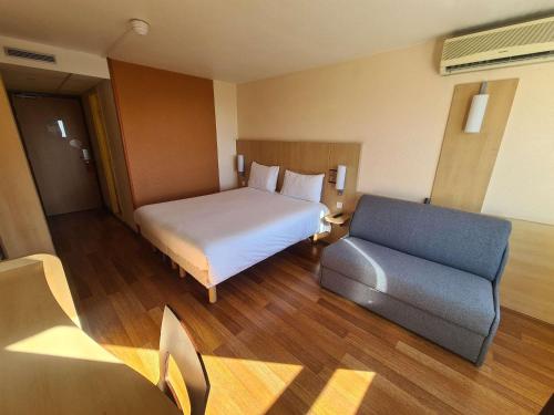 a hotel room with a bed and a couch at ibis Marseille Centre Gare Saint Charles in Marseille