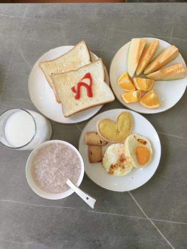Tres platos de desayuno con tostadas y fruta. en Borui Starry Sky View Hotel (Chongqing Jiefangbei Pedestrian Street Hongyadong Branch), en Chongqing