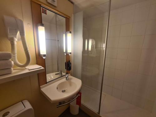 a bathroom with a sink and a glass shower at ibis Marseille Centre Gare Saint Charles in Marseille