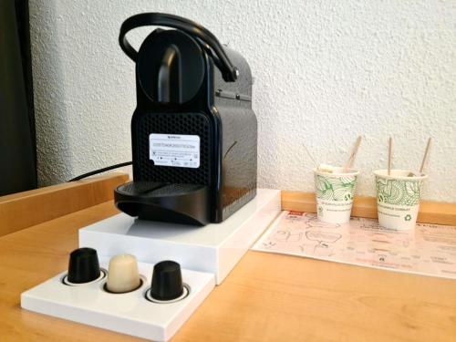 a black iron sitting on top of a desk with cups at ibis Marseille Centre Gare Saint Charles in Marseille