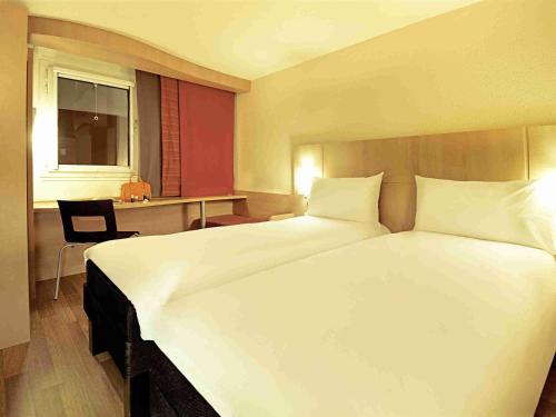 a hotel room with a large bed and a desk at ibis Marseille Centre Gare Saint Charles in Marseille