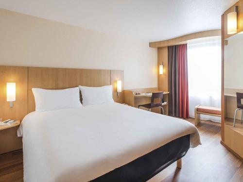 Una gran cama blanca en una habitación de hotel. en ibis Nantes Centre Tour Bretagne, en Nantes