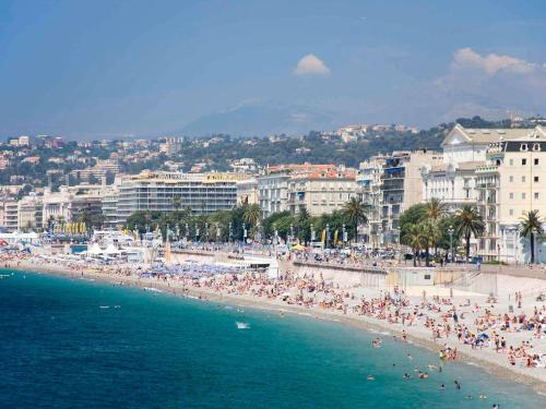 a beach with a lot of people in the water at ibis Nice Centre Gare in Nice