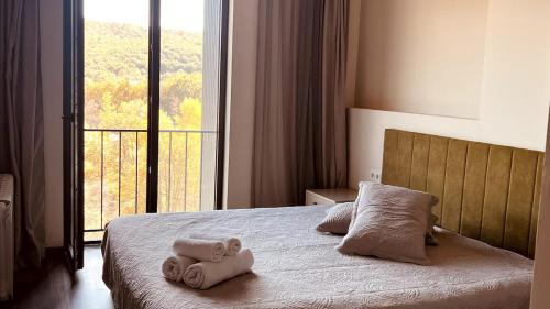 a bedroom with towels on a bed with a window at Lovely Aparthotel in Tsaghkadzor in Tsaghkadzor
