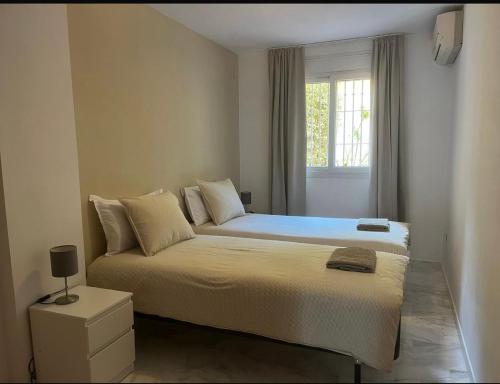 a bedroom with a large bed with a window at Spacious family friendly 3 bedroom home B' Pueblo - swimming pool - games room & sunny terrasse in Benalmádena