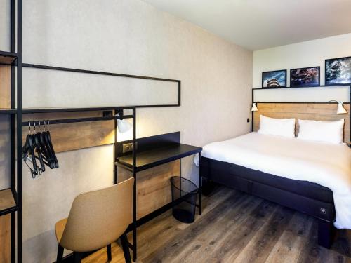 a hotel room with a bed and a desk at Ibis Pau Centre in Pau