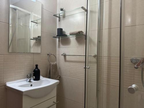 a bathroom with a sink and a glass shower at Spacious family friendly 3 bedroom home B' Pueblo - swimming pool - games room & sunny terrasse in Benalmádena