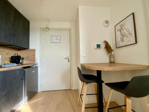 a kitchen with a table and chairs in a room at Les Loges de la Mer - Pérols in Pérols