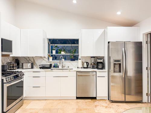 a kitchen with white cabinets and stainless steel appliances at 3BR Villa with Serene Poolside Views - CAL1 - HH in Hidden Hills