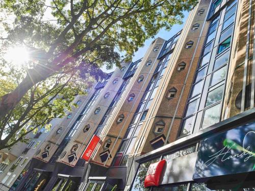 a tall brick building with the sun shining on it at ibis Paris La Villette Cité des Sciences 19ème in Paris