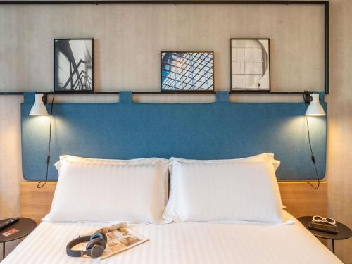 a bedroom with a bed with two white pillows at ibis Paris CDG Airport in Roissy-en-France