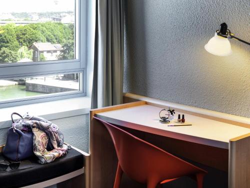 a hotel room with a desk and a window at ibis Paris La Villette Cité des Sciences 19ème in Paris