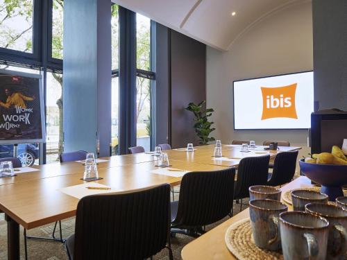 a conference room with tables and chairs and a screen at ibis Paris La Villette Cité des Sciences 19ème in Paris