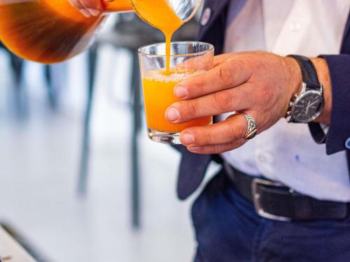 a man pouring orange juice into a glass at ibis Paris La Villette Cité des Sciences 19ème in Paris