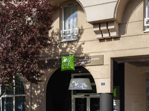 un bâtiment avec un panneau vert devant une fenêtre dans l'établissement ibis Styles Paris Porte de Versailles - Mairie d'Issy, à Issy-les-Moulineaux