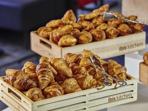 two wooden boxes filled with croissants and other pastries at ibis Paris CDG Airport in Roissy-en-France