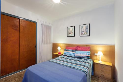 a bedroom with a bed and two night stands and two lamps at Vivalidays Joan - Blanes in Blanes