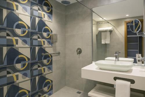 a bathroom with a sink and a shower at Phoenix Hotel & Wellness in Sheikh Zayed