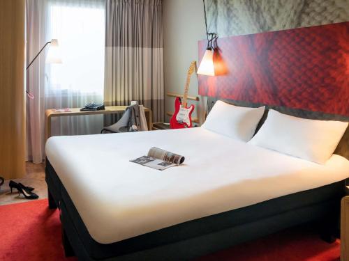 a hotel room with a bed with a book on it at ibis Rueil-Malmaison Centre in Rueil-Malmaison