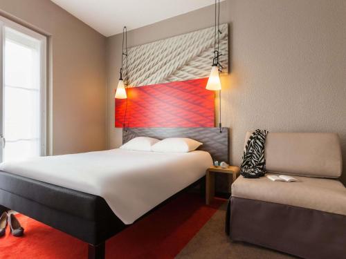 a hotel room with a bed and a chair at ibis Rueil-Malmaison Centre in Rueil-Malmaison