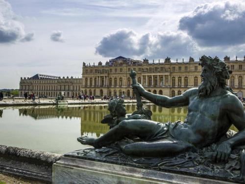 a statue in front of a large building at ibis Versailles Château in Versailles
