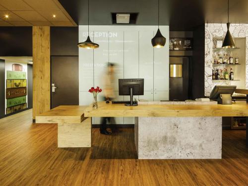 a lobby with a desk with a television on it at ibis Versailles Château in Versailles
