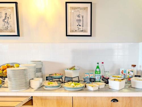 eine Küchentheke mit Tellern und Schüsseln mit Lebensmitteln in der Unterkunft ibis Marne La Vallee Champs-sur-Marne in Champs-Sur-Marne