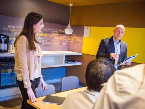 a man and woman standing in a room with a group of people at ibis Paris Coeur d'Orly Airport in Orly