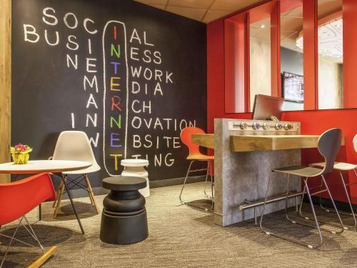 a restaurant with tables and chairs and a chalkboard wall at ibis Poitiers Centre in Poitiers