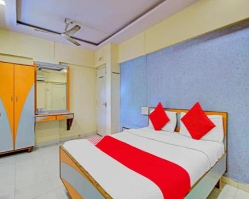 ムンバイにあるHotel Anil Residencyのベッドルーム1室(赤い枕のベッド1台付)