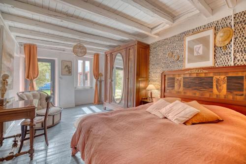 a bedroom with a large bed and a desk at Les Jardins d'Ortigia - Confort in Dourgne