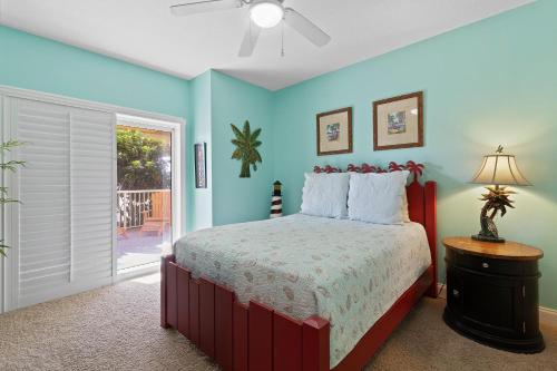a bedroom with a bed with blue walls at Atlantic Villas 103 in New Smyrna Beach